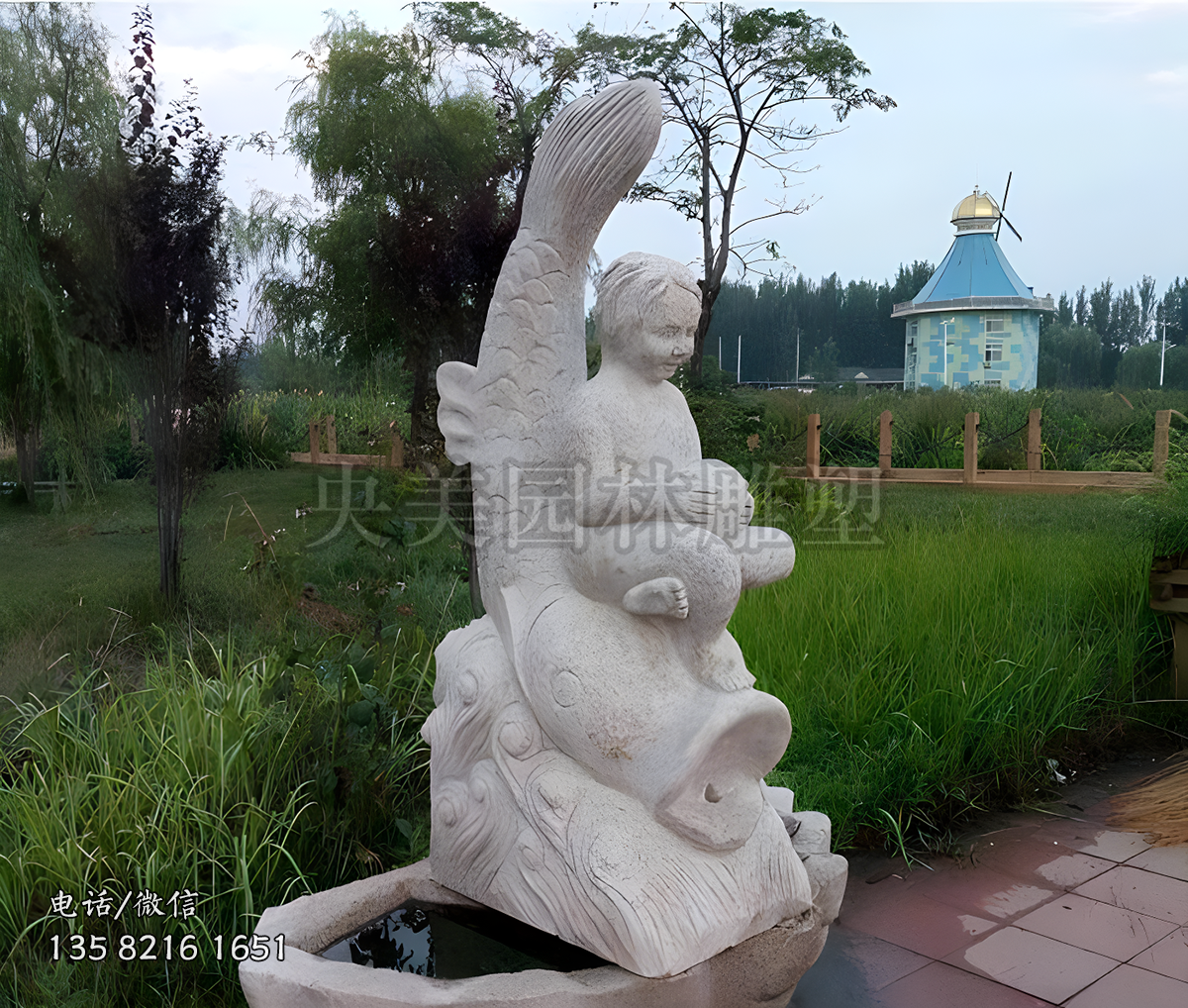 馱著一個小女孩的吐水的魚石雕