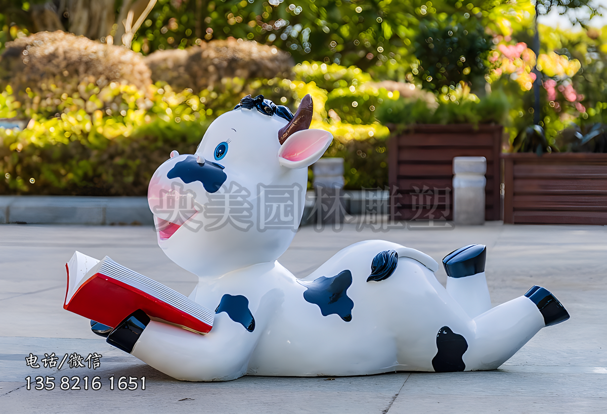 爬地上看書的卡通小奶牛雕塑